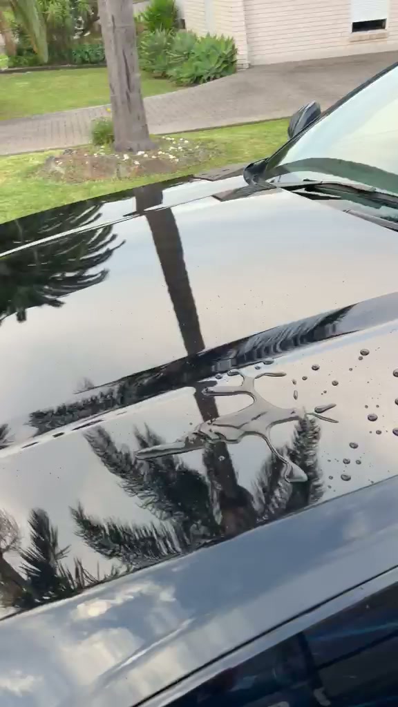 Water beading across glossy black paint